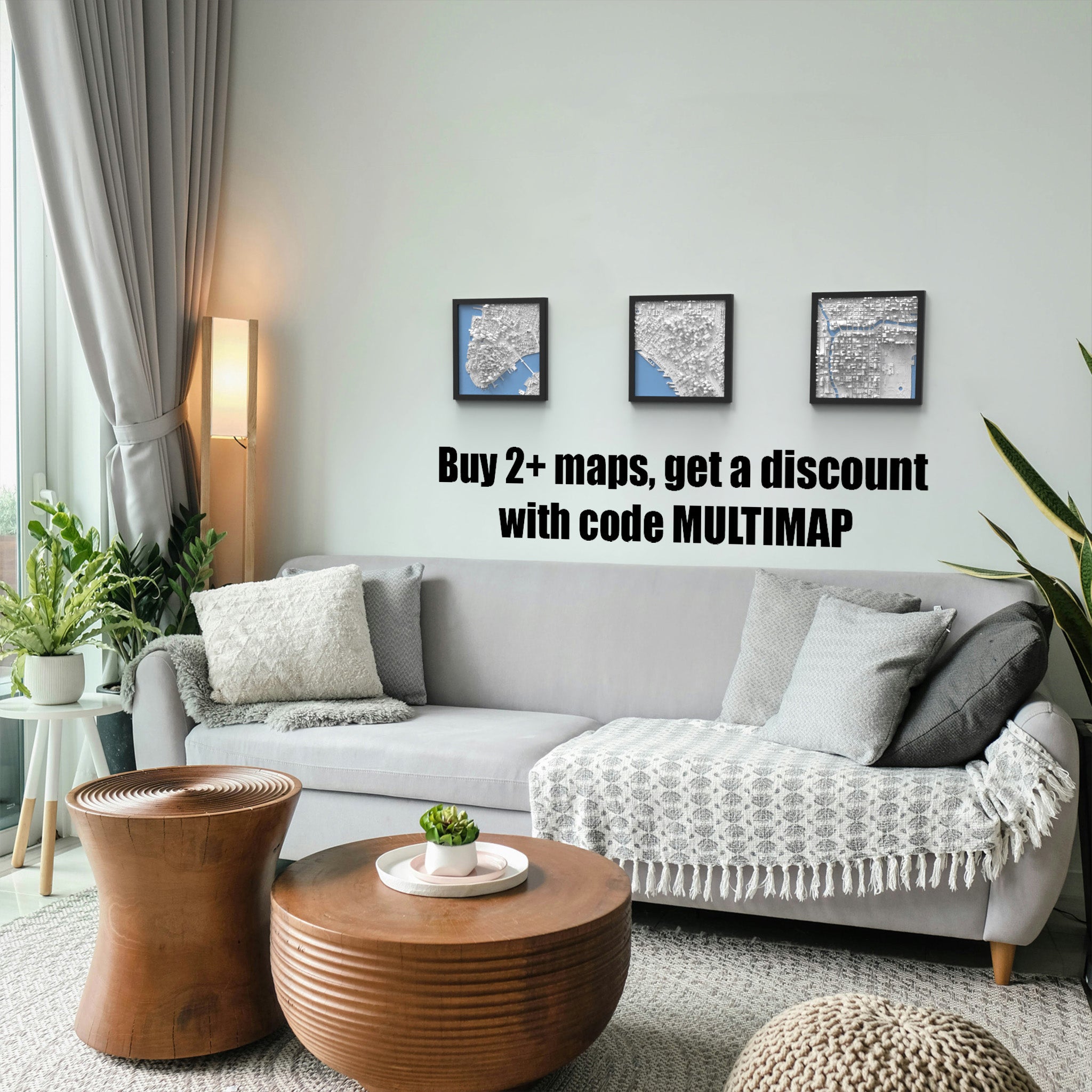 A modern living room with a gray sofa, patterned cushions, wooden tables, and striking wall art—three Chicago 3D Map prints above a sign: Buy 2+ maps, get a discount with code MULTIMAP.