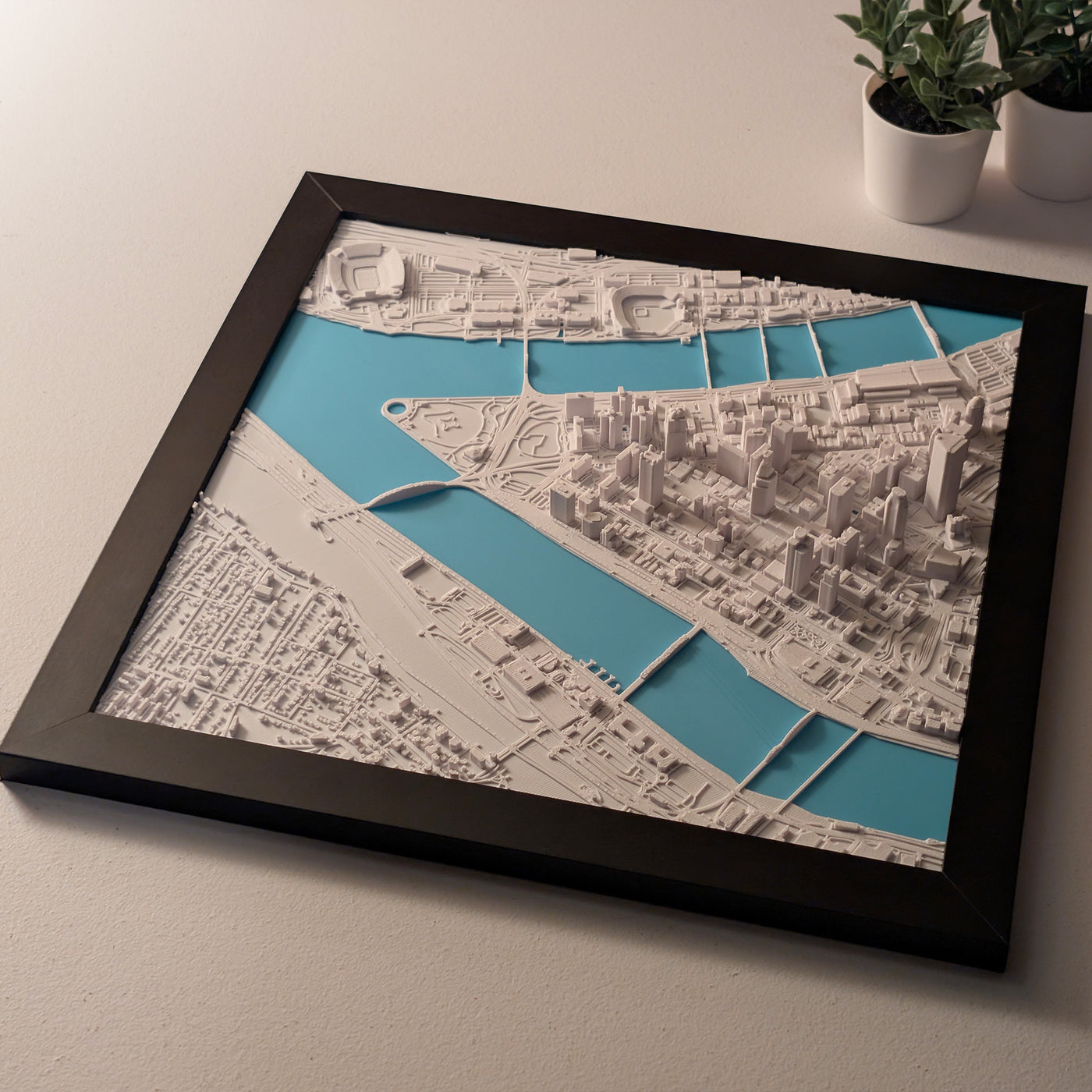 Framed cityscape map with a black frame on a light surface.