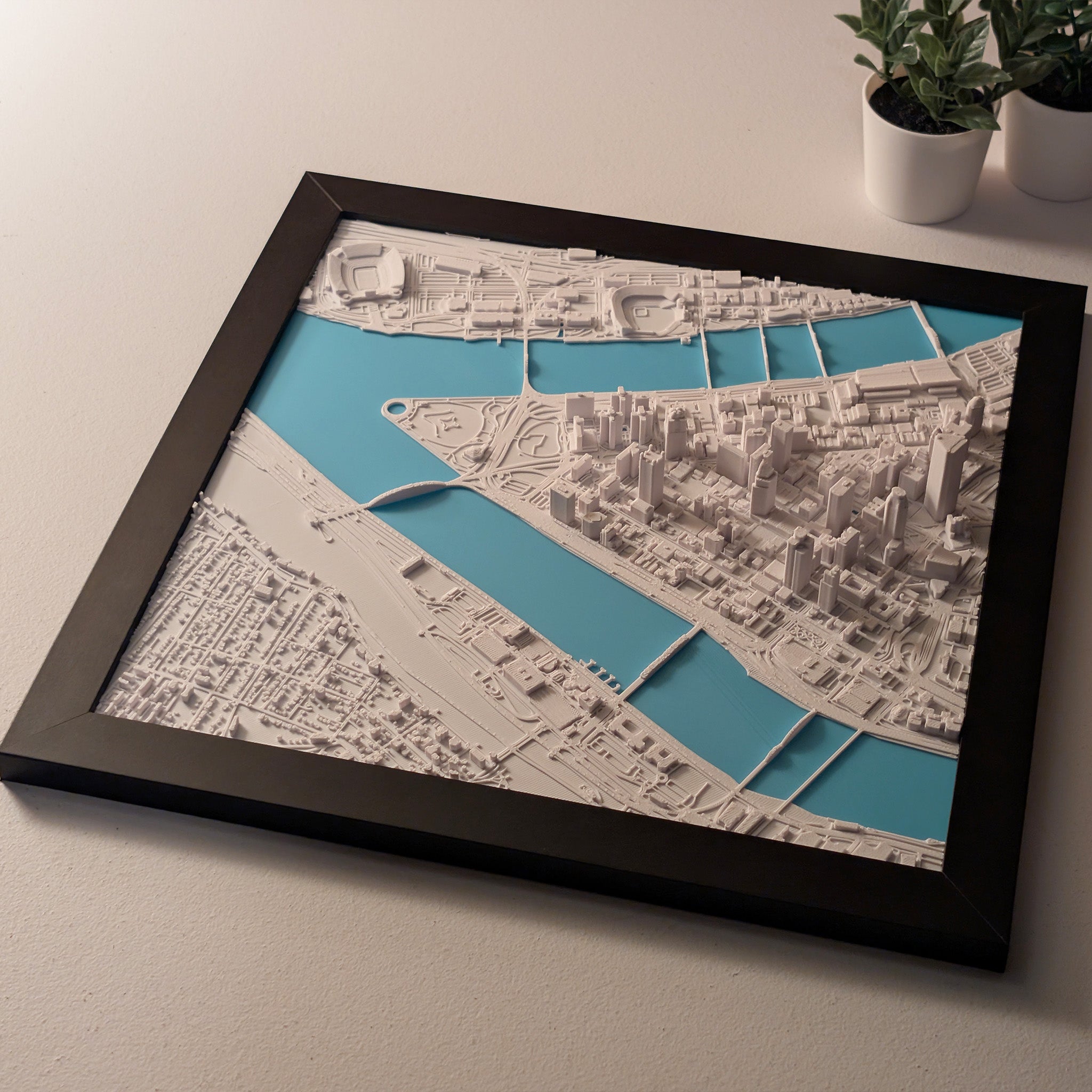 Framed cityscape map with a black frame on a light surface.